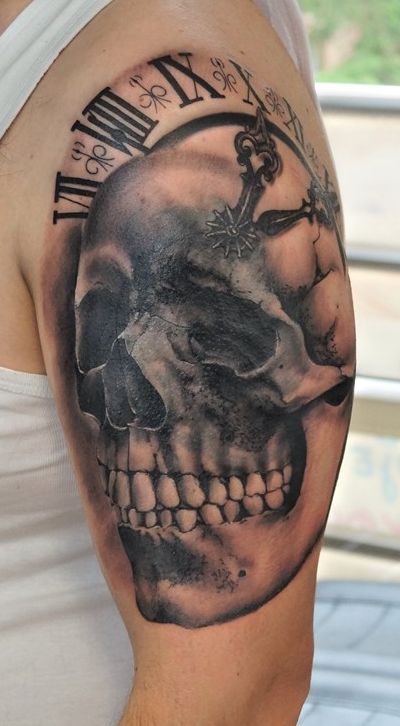 czaszka i zegar na ramieniu tatuaż