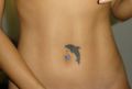 delfin tatuaż na brzuchu