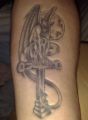 skrzydlaty demon krzyż tatuaż na ręce