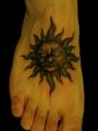 tatuaż słońce na stopie