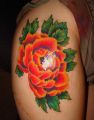 duży kwiat tatuaż na udzie kobiety