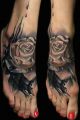 white rose on foot tattoo