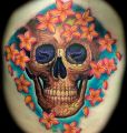 uśmiechnięta czaszka i kwiaty tatuaże