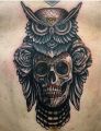 skull and owl on chest tattoo