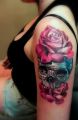 roses and skull tattoos on arm