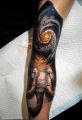 galaktyka i mamut tatuaż na ręce
