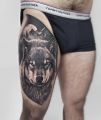 wilk tatuaż na udzie mężczyzny