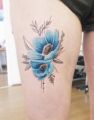 niebieskie kwiaty tatuaże na udzie