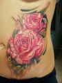 pink roses tattoo on ribs