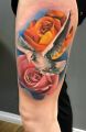 gołąb i kwiaty tatuaże na udzie